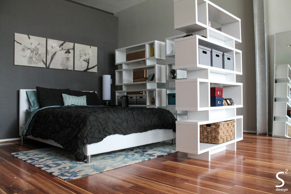 Photo of an industrial mezzanine bedroom in Houston with grey walls and medium hardwood flooring.