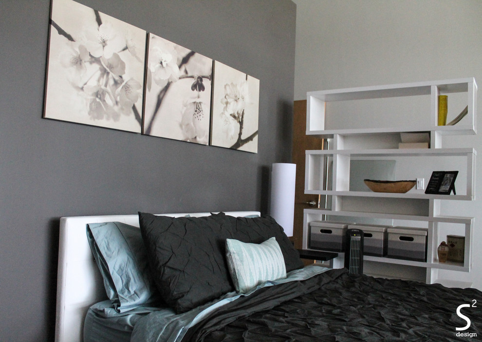 Ejemplo de dormitorio tipo loft urbano con paredes grises y suelo de madera en tonos medios