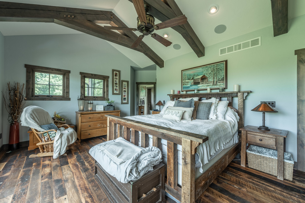 Ejemplo de dormitorio principal rústico de tamaño medio con paredes azules, suelo de madera oscura y suelo multicolor