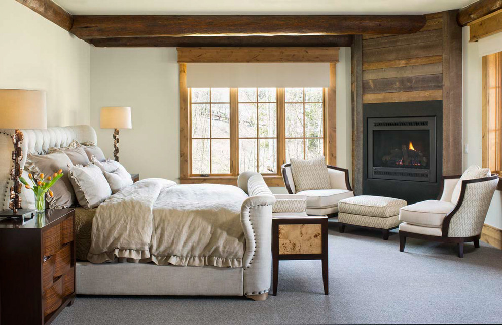 This is an example of a rustic master bedroom in Denver with white walls, carpet, a corner fireplace and feature lighting.