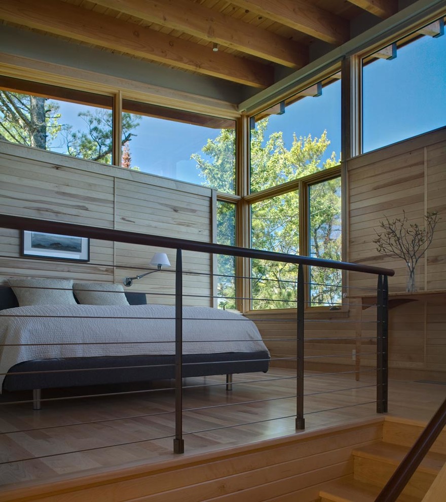 Diseño de dormitorio tipo loft de estilo americano pequeño con paredes beige y suelo de madera clara