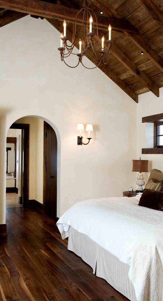 Inspiration for a large rustic master medium tone wood floor bedroom remodel in Other with beige walls and no fireplace
