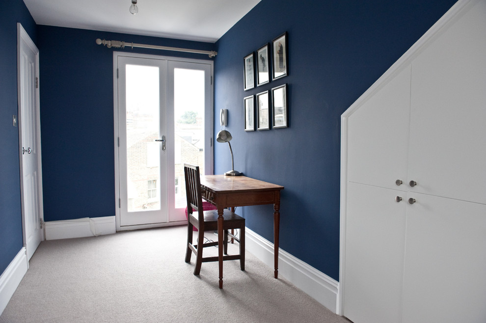 This is an example of a large modern guest bedroom in London with blue walls and carpet.