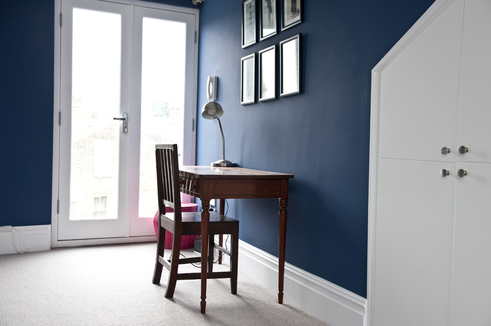 Immagine di una grande camera degli ospiti minimalista con pareti blu e moquette