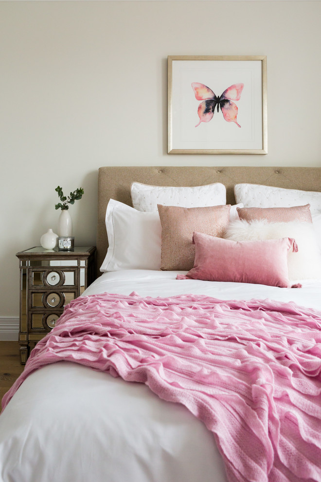 Imagen de dormitorio clásico de tamaño medio con paredes beige y suelo de madera clara