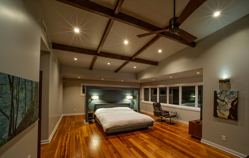 Ejemplo de habitación de invitados actual grande con paredes grises y suelo de madera en tonos medios