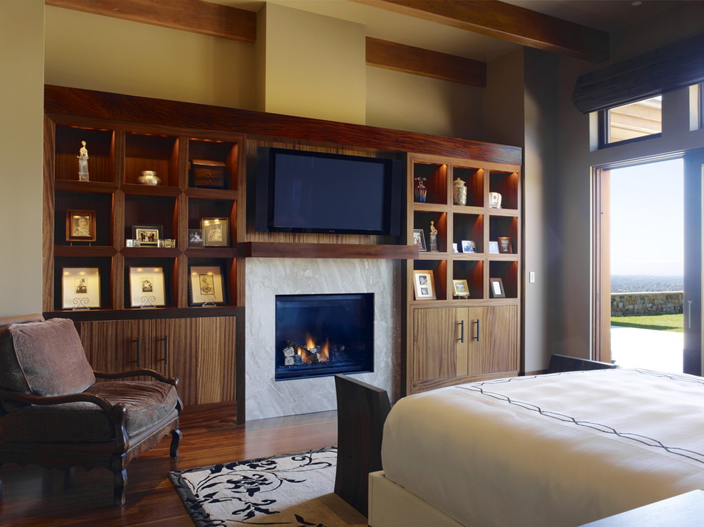 サンフランシスコにある広いコンテンポラリースタイルのおしゃれな主寝室 (ベージュの壁、無垢フローリング、標準型暖炉、石材の暖炉まわり、茶色い床) のインテリア