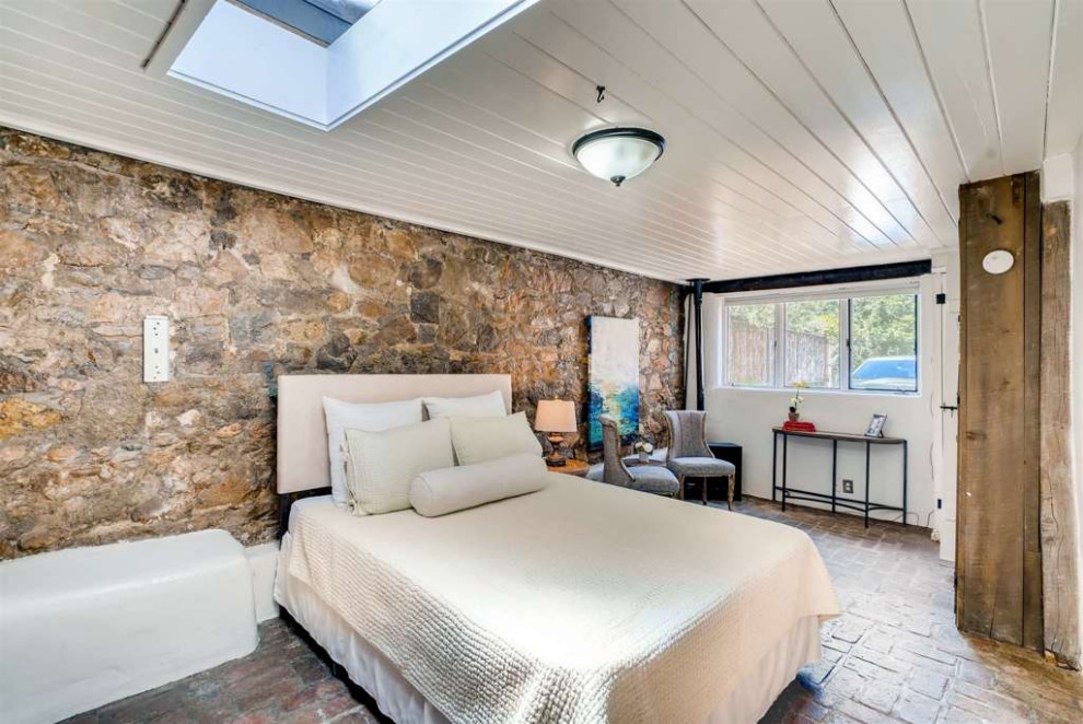 Idéer för amerikanska sovrum, med vita väggar, tegelgolv, en öppen hörnspis och rött golv