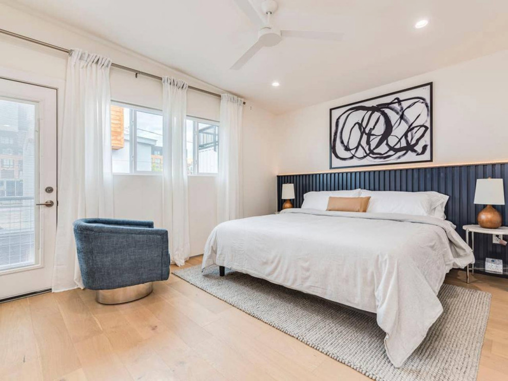 Esempio di una camera da letto contemporanea con pareti bianche, parquet chiaro e pavimento beige
