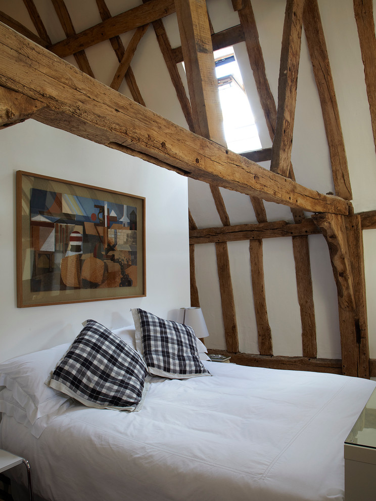 Immagine di un'In mansarda camera matrimoniale country di medie dimensioni con pareti bianche e pavimento in legno massello medio