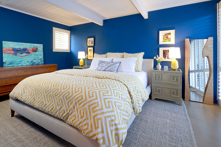 Photo of a retro master bedroom in San Francisco with blue walls and concrete flooring.