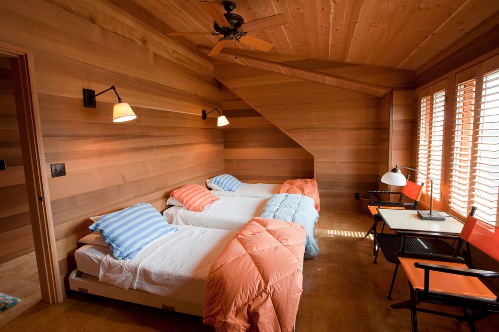 Aménagement d'une grande chambre d'amis bord de mer avec un mur beige, un sol en bois brun et aucune cheminée.