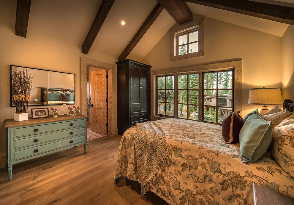 Diseño de dormitorio rural con paredes beige y suelo de madera en tonos medios