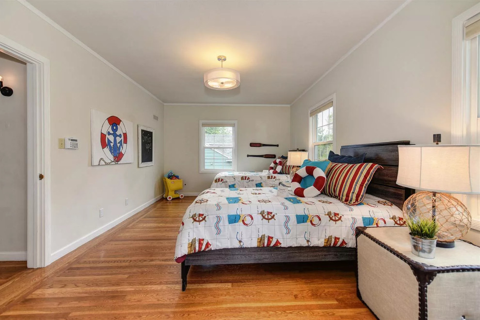 Modelo de habitación de invitados costera de tamaño medio sin chimenea con paredes blancas, suelo de madera en tonos medios y suelo multicolor