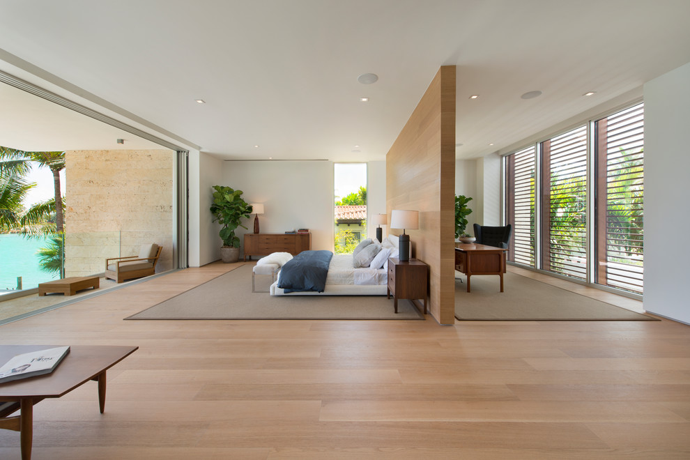 Cette image montre une grande chambre parentale minimaliste avec un mur blanc, parquet en bambou et aucune cheminée.