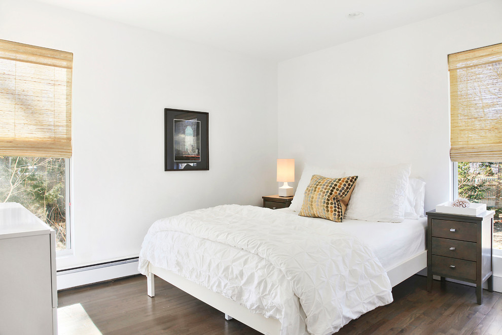 На фото: гостевая спальня среднего размера, (комната для гостей) в стиле неоклассика (современная классика) с белыми стенами, темным паркетным полом и коричневым полом без камина с
