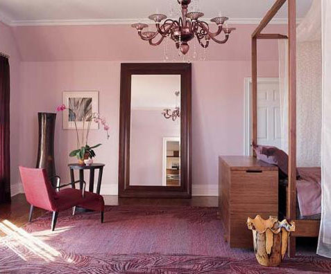 Modelo de dormitorio principal actual de tamaño medio sin chimenea con paredes púrpuras y suelo de madera en tonos medios