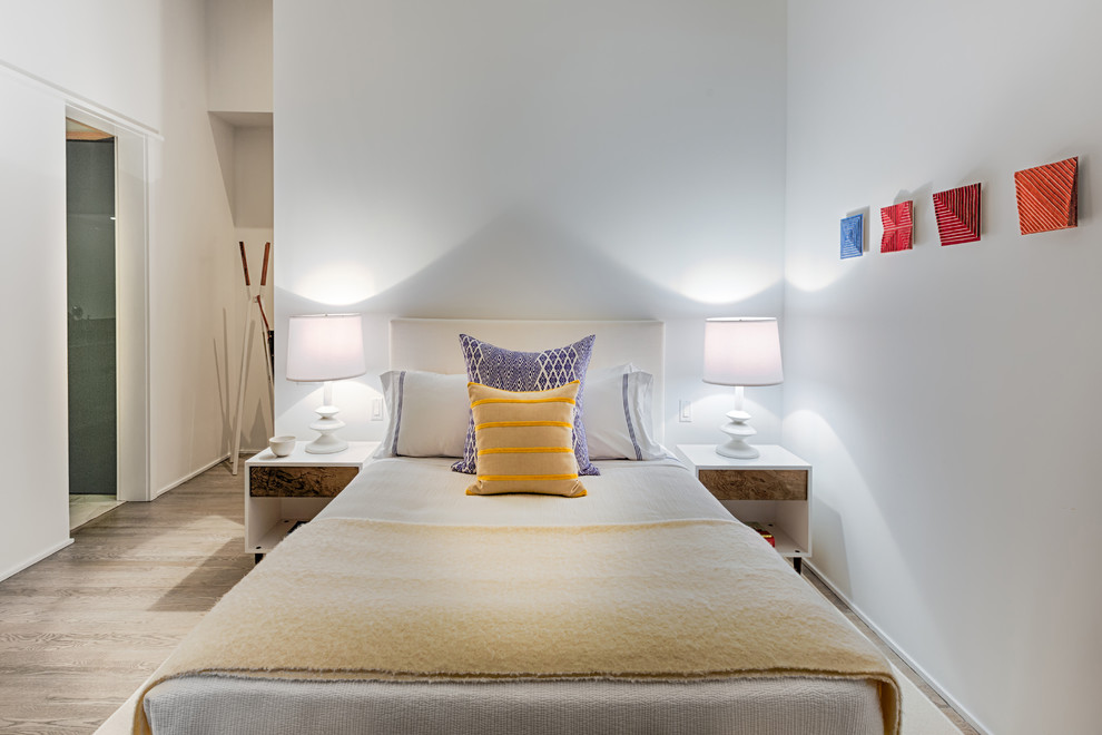 Cette photo montre une chambre d'amis moderne de taille moyenne avec un mur blanc et parquet clair.