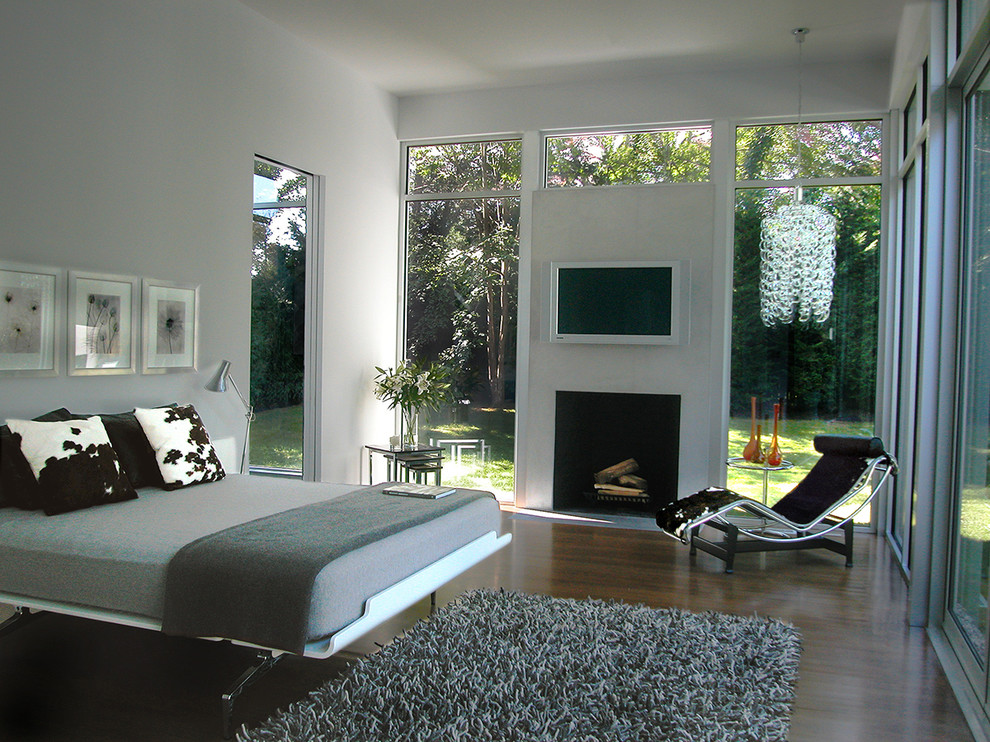 Стильный дизайн: большая хозяйская спальня в стиле модернизм с серыми стенами, темным паркетным полом и стандартным камином - последний тренд