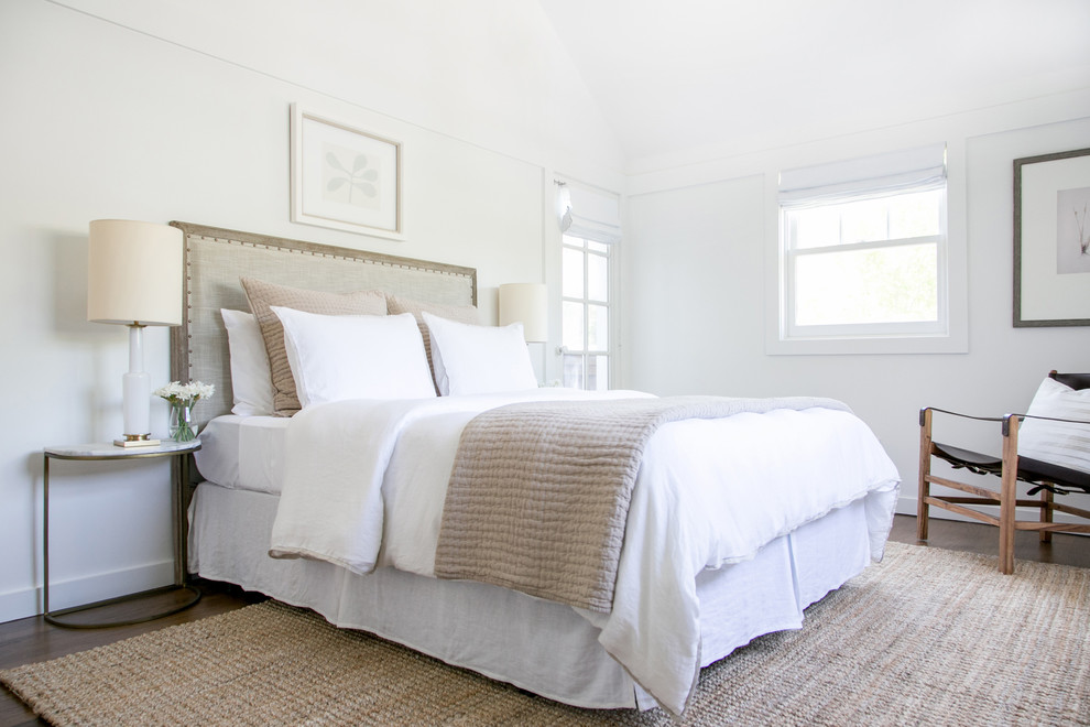 Réalisation d'une chambre d'amis tradition de taille moyenne avec un mur blanc et un sol en bois brun.