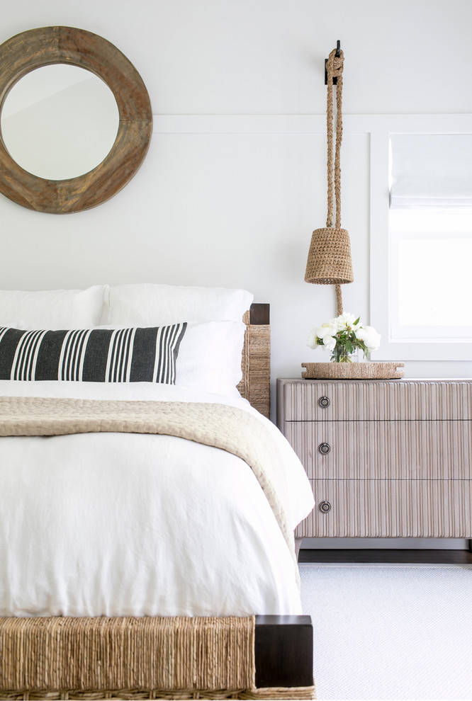 Huge beach style master medium tone wood floor and brown floor bedroom photo in New York with white walls and no fireplace