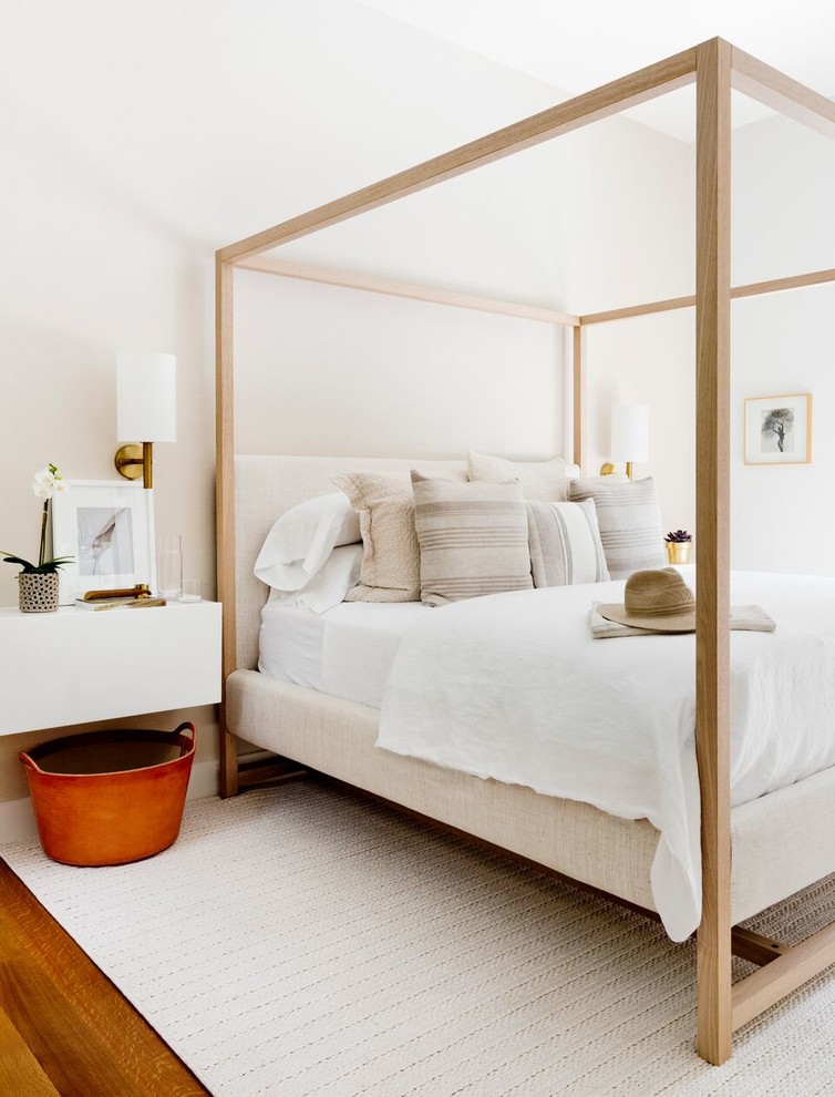 Aménagement d'une chambre d'amis moderne avec un mur beige, un sol en bois brun et un sol marron.