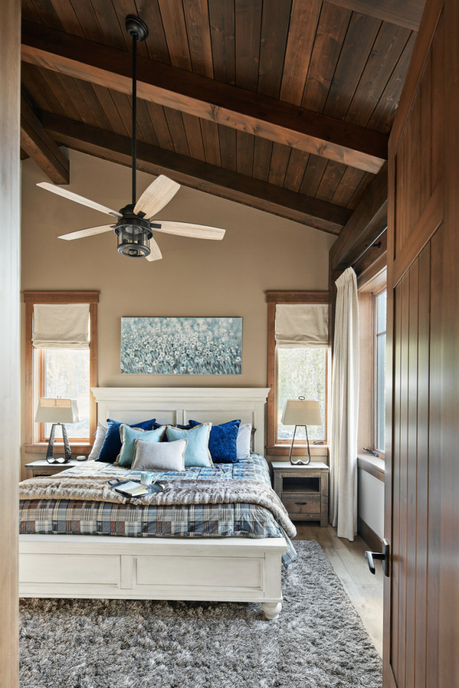 Diseño de habitación de invitados abovedada rural grande con vigas vistas, madera, paredes marrones, suelo de madera en tonos medios y suelo marrón