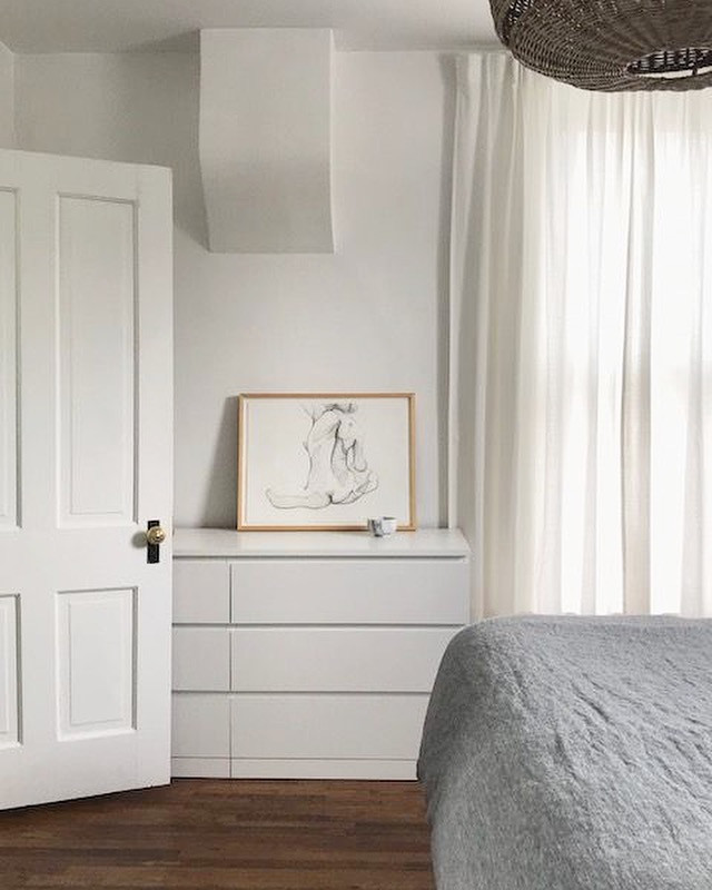 Immagine di una piccola camera degli ospiti scandinava con pareti bianche, pavimento in legno massello medio, nessun camino e pavimento marrone