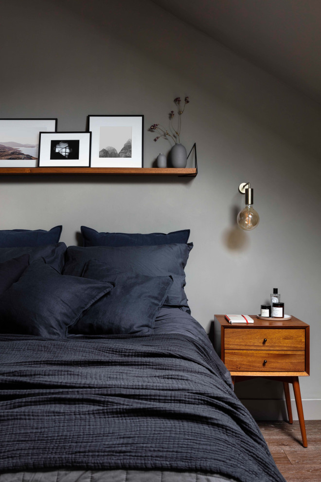 Imagen de dormitorio principal retro de tamaño medio con paredes grises, suelo de madera en tonos medios y suelo marrón