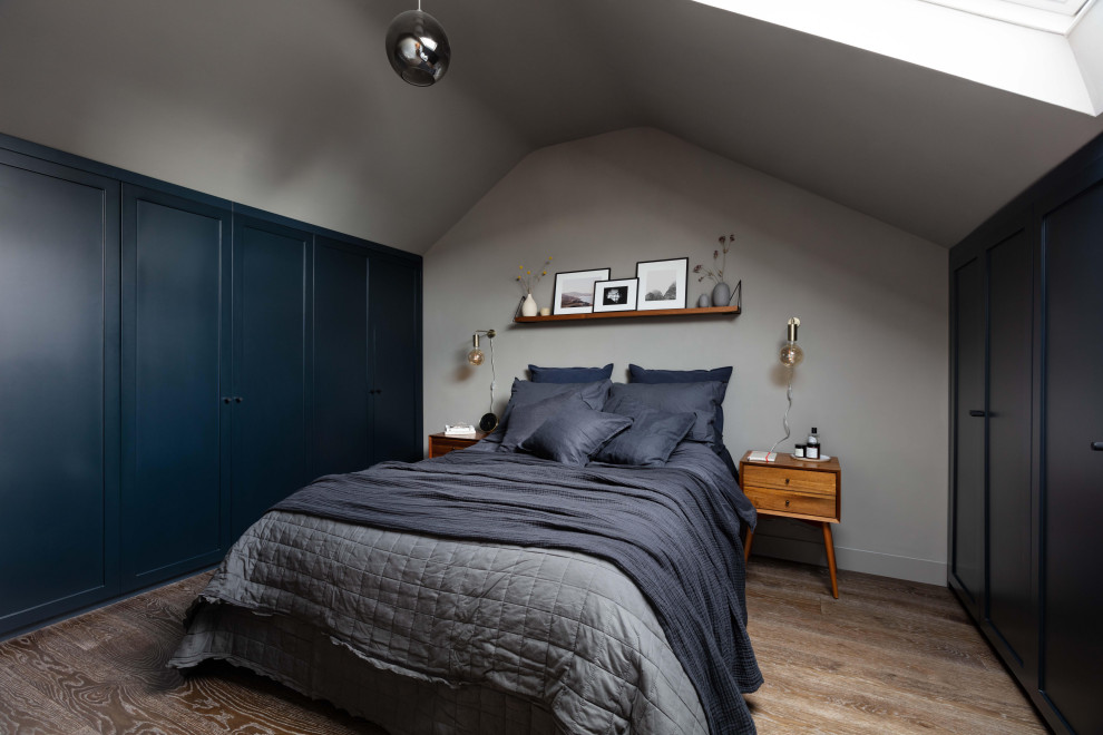 ロンドンにある中くらいなトランジショナルスタイルのおしゃれな主寝室 (グレーの壁、無垢フローリング、茶色い床) のインテリア