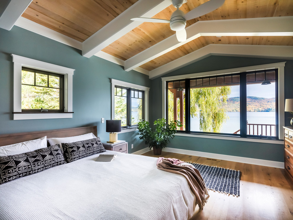 Imagen de dormitorio principal rústico grande con paredes verdes, suelo de madera clara y suelo beige