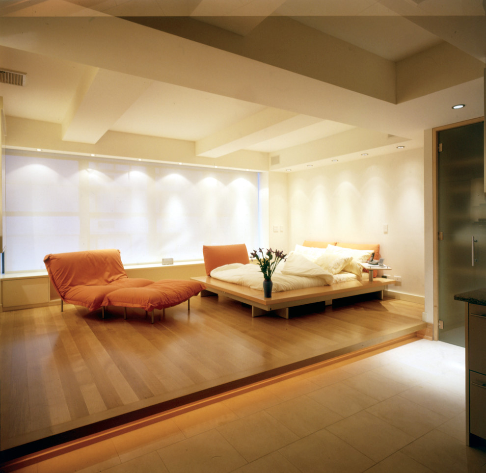 Aménagement d'une grande chambre mansardée ou avec mezzanine contemporaine avec un mur blanc et parquet clair.