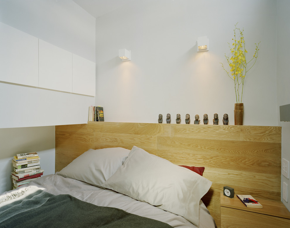 Example of a minimalist bedroom design in New York with white walls