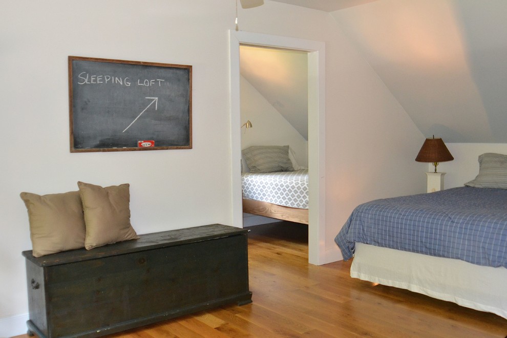 Idee per una camera degli ospiti costiera di medie dimensioni con pareti bianche, pavimento in legno massello medio e pavimento marrone