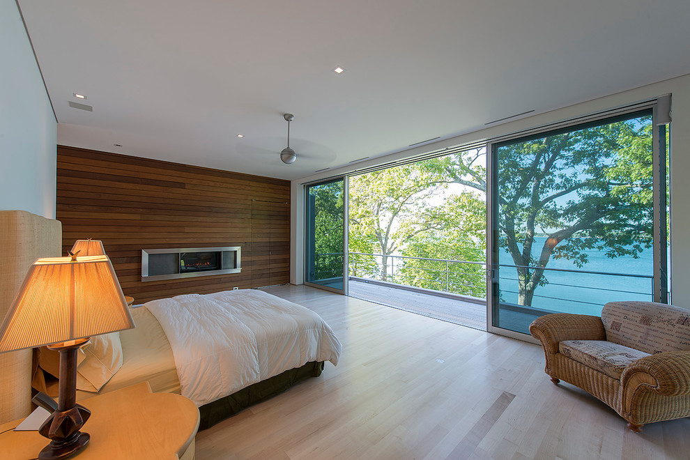 Свежая идея для дизайна: спальня в современном стиле с белыми стенами, светлым паркетным полом и горизонтальным камином - отличное фото интерьера