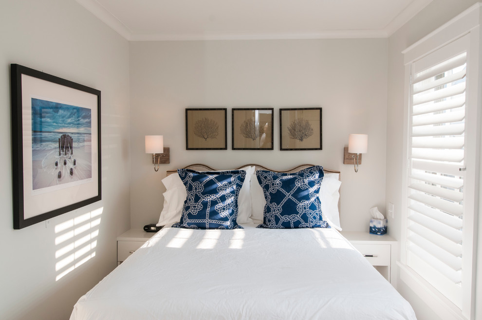 Immagine di una camera degli ospiti stile marino di medie dimensioni con pareti bianche, pavimento in legno massello medio e nessun camino
