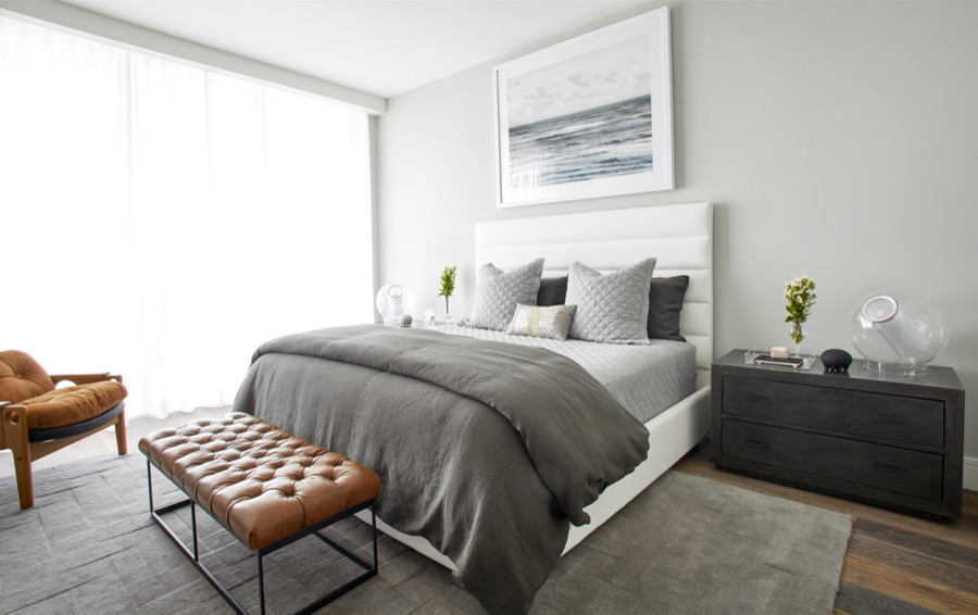 Example of a mid-sized minimalist master medium tone wood floor bedroom design in Miami with gray walls