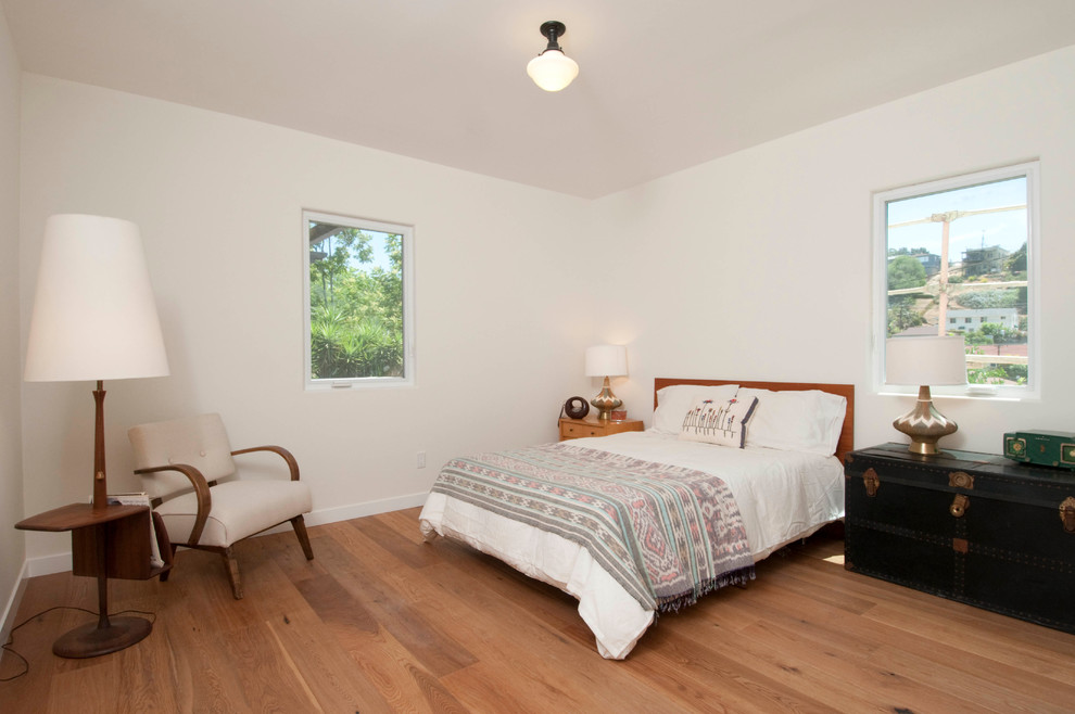 Exemple d'une chambre parentale méditerranéenne de taille moyenne avec un mur blanc et un sol en bois brun.