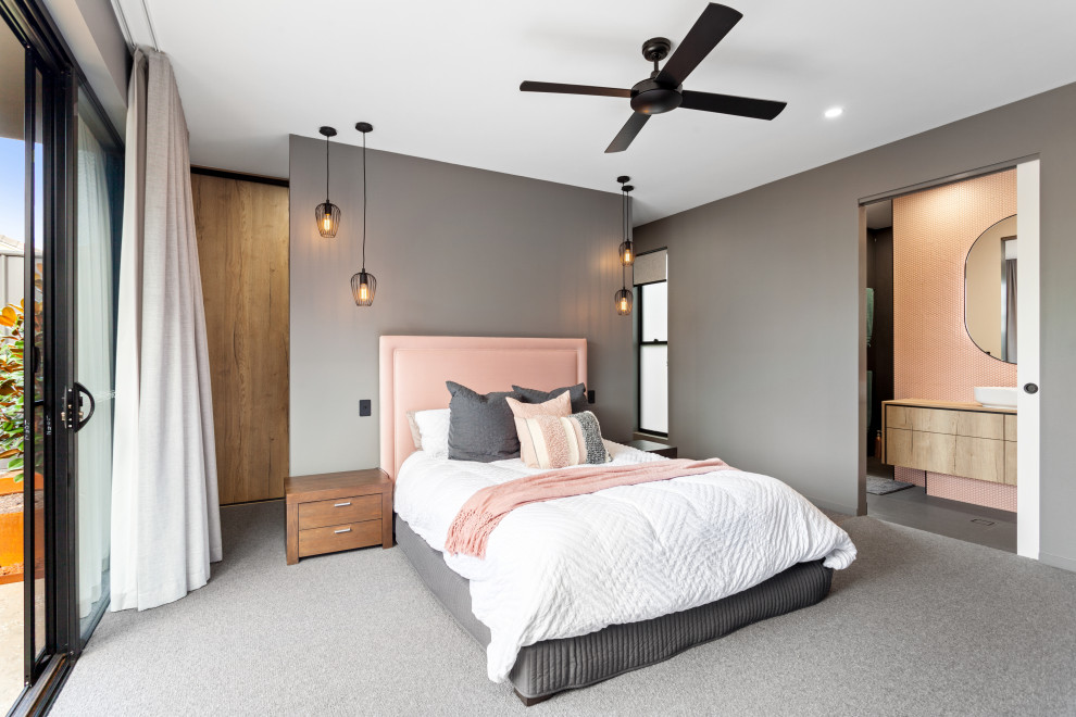 На фото: хозяйская спальня в современном стиле с серыми стенами, ковровым покрытием и серым полом без камина