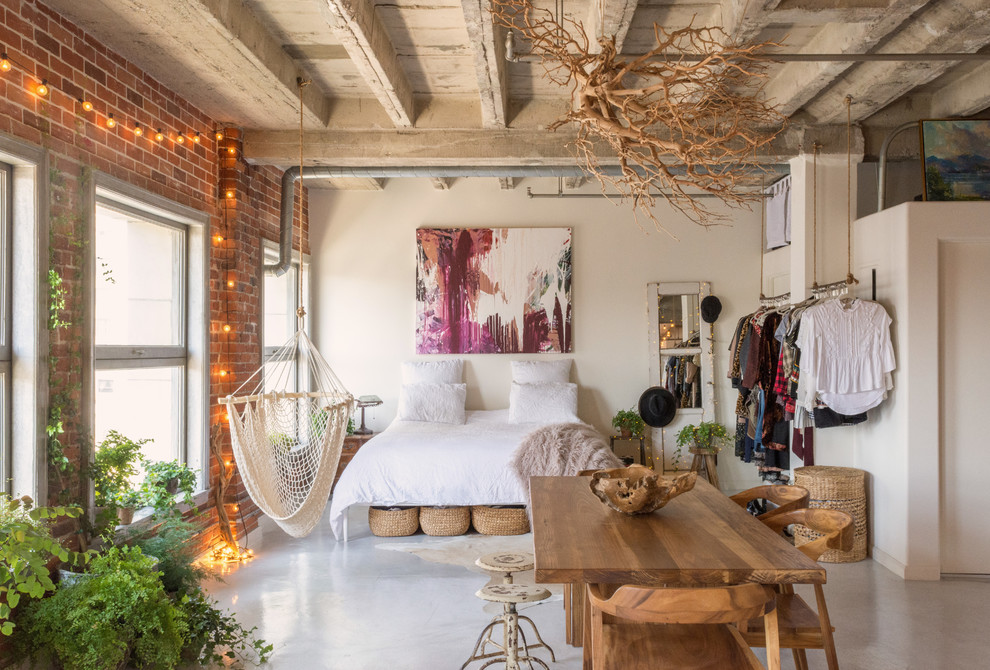 Bohemian bedroom in Los Angeles with white walls, concrete flooring and grey floors.