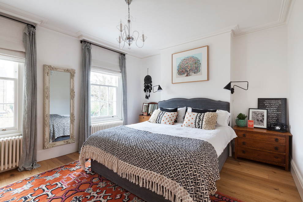 Inspiration for an eclectic bedroom in Other with white walls and light hardwood flooring.