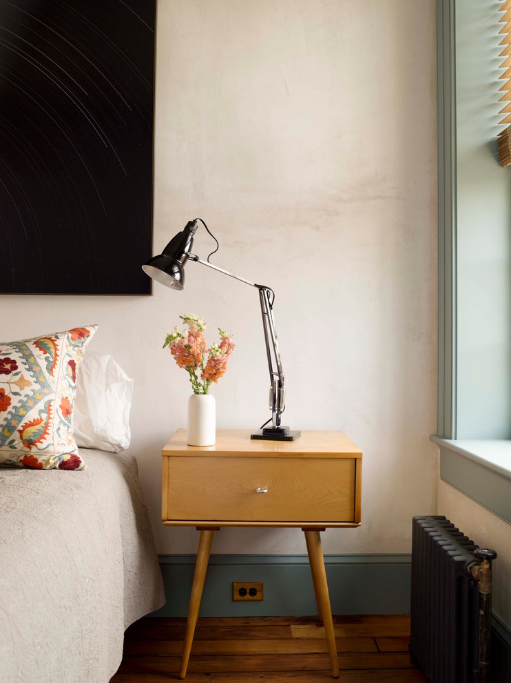 Eklektisches Schlafzimmer mit beiger Wandfarbe und braunem Holzboden in New York