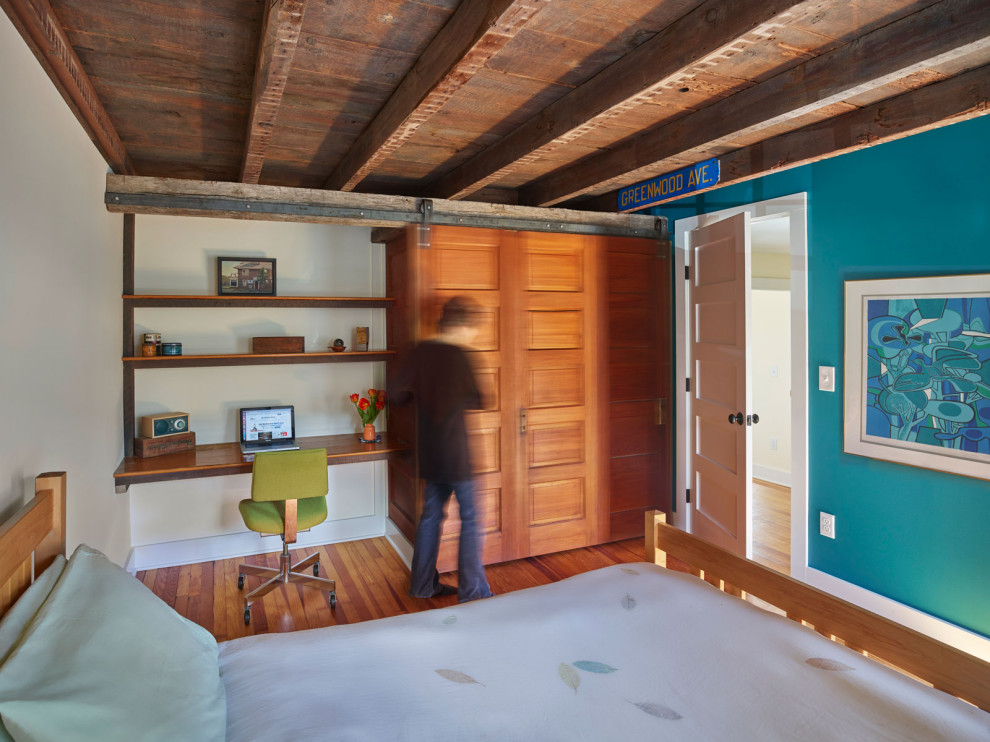 Diseño de dormitorio bohemio grande sin chimenea con paredes azules, suelo de madera en tonos medios, suelo marrón y vigas vistas