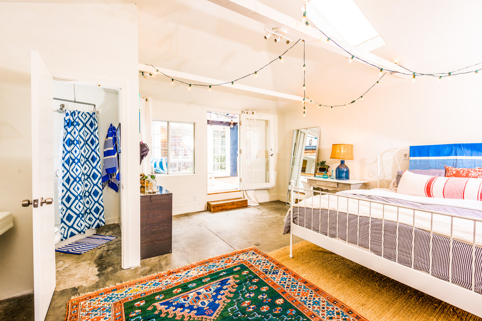 Esempio di una camera da letto boho chic con pareti bianche e pavimento in cemento