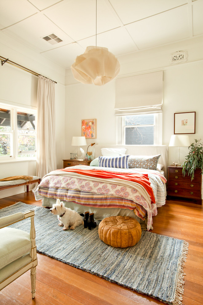 パースにあるエクレクティックスタイルのおしゃれな寝室 (白い壁、無垢フローリング、オレンジの床) のレイアウト
