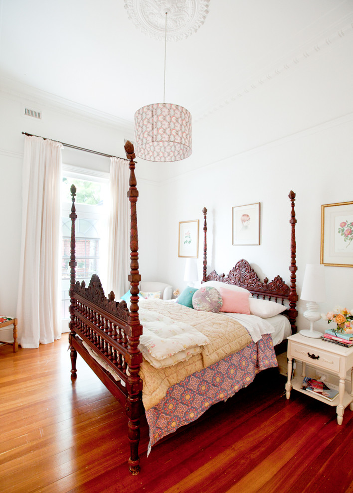 Ejemplo de dormitorio bohemio con paredes blancas y suelo de madera oscura