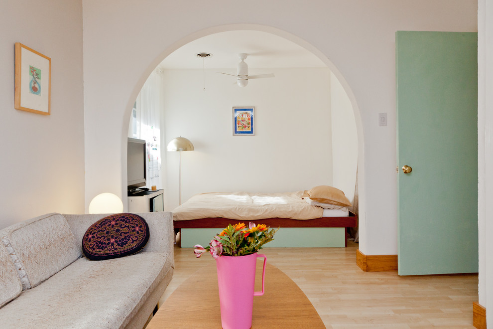 Foto di una camera da letto boho chic con pareti bianche e parquet chiaro