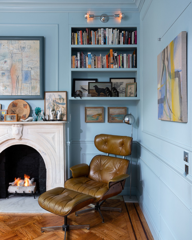 ニューヨークにある中くらいなエクレクティックスタイルのおしゃれな主寝室 (青い壁、無垢フローリング、標準型暖炉、石材の暖炉まわり、茶色い床)