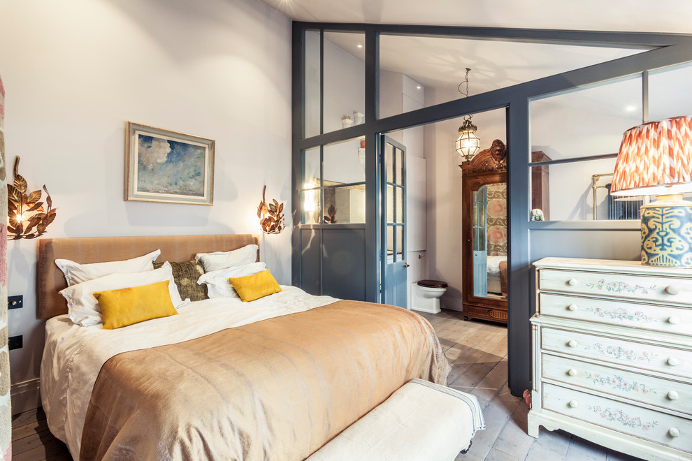 This is an example of a medium sized eclectic master bedroom in London with grey walls, light hardwood flooring and grey floors.