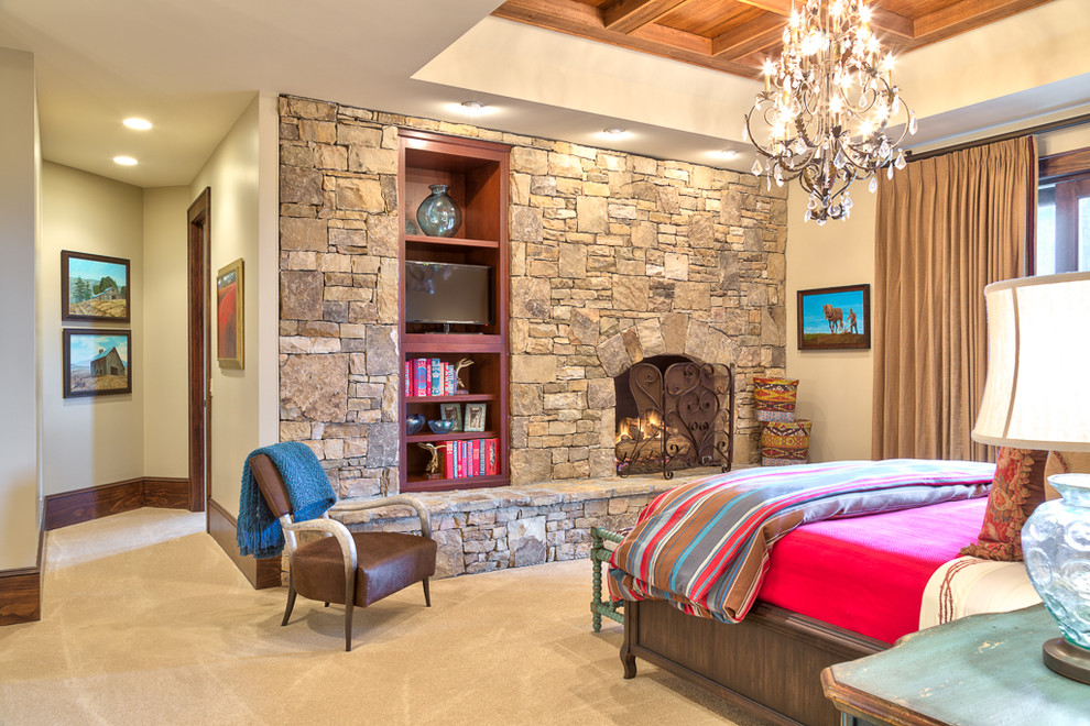 Großes Uriges Hauptschlafzimmer mit beiger Wandfarbe, Teppichboden, Kamin, Kaminumrandung aus Stein und beigem Boden in Charlotte